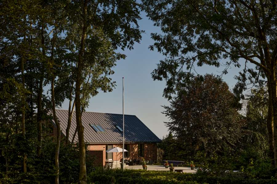 Sommerlys sænker sig over stålprofiler i skoven, Klæstruplundvej 11, 9240 Nibe